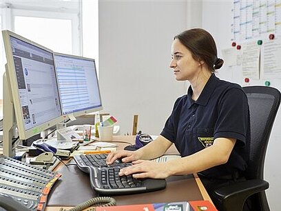 Eine junge Frau bedient einen Computer.