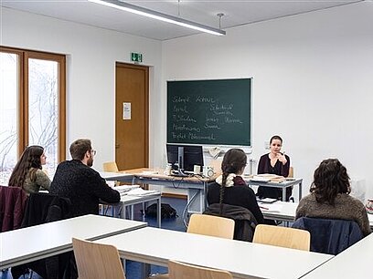 Eine Klasse sitzt im Klassenzimmer und wird unterrichtet.