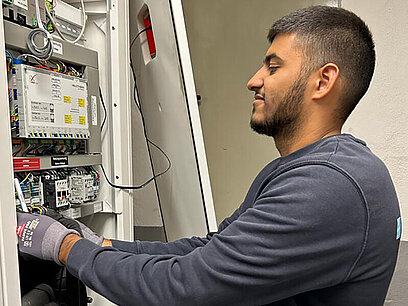 Raheem arbeitet an einer Elektroschaltanlage.